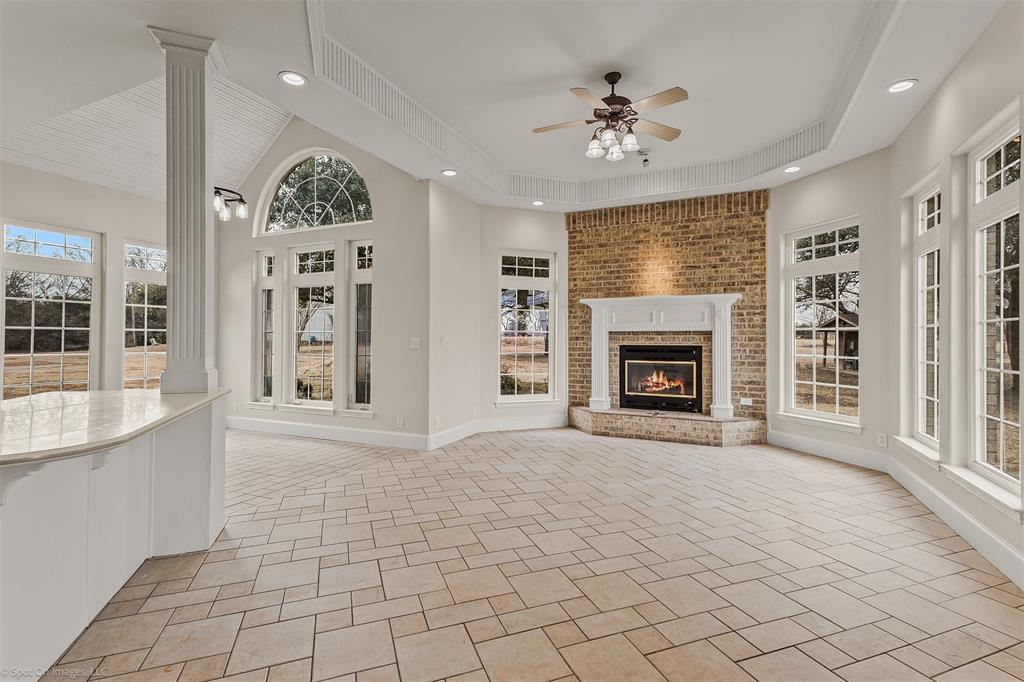 15183 Valley View Forney, TX 75126 - Photo 10 of 38 an empty room with windows fireplace and a kitchen view