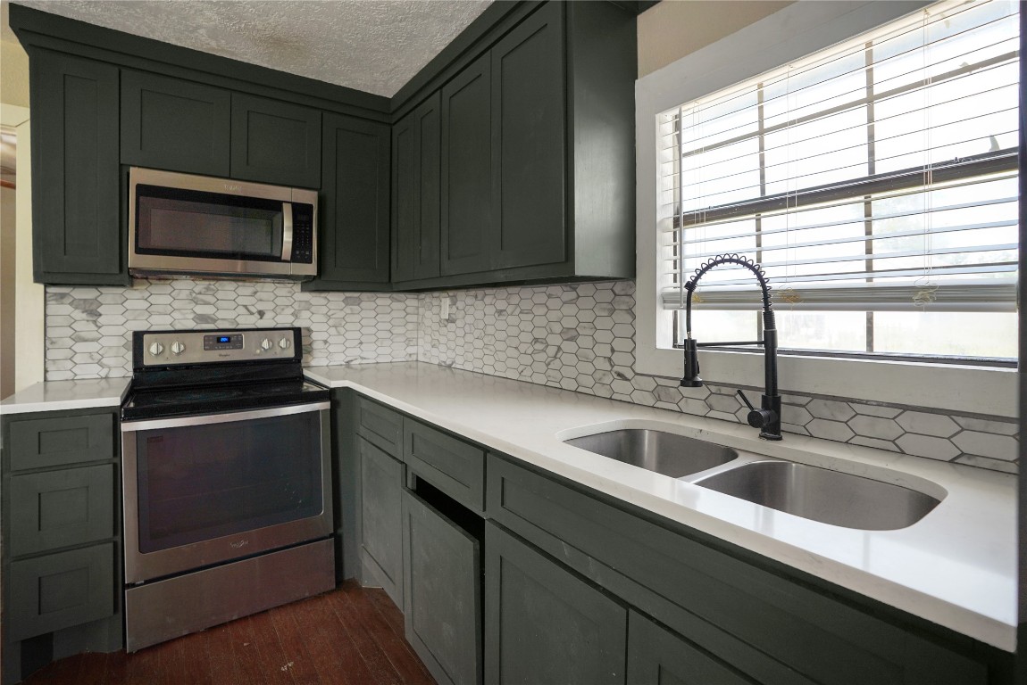 207 Riverside Street Highlands, TX 77562 - Photo 17 of 29 a kitchen with a sink stove and microwave