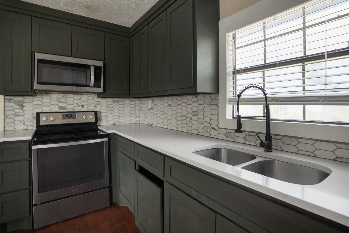 207 Riverside Street Highlands, TX 77562 - Photo 19 of 29 a kitchen with a sink stove and microwave