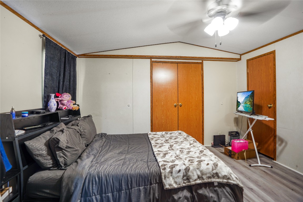 207 Riverside Street Highlands, TX 77562 - Photo 25 of 29 a bedroom with a bed and a chandelier