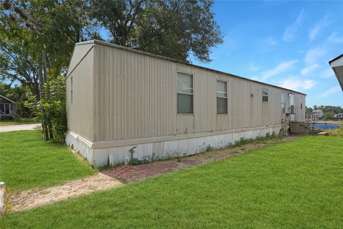 207 Riverside Street Highlands, TX 77562 - Photo 10 of 29 a backyard of a house with large trees and plants
