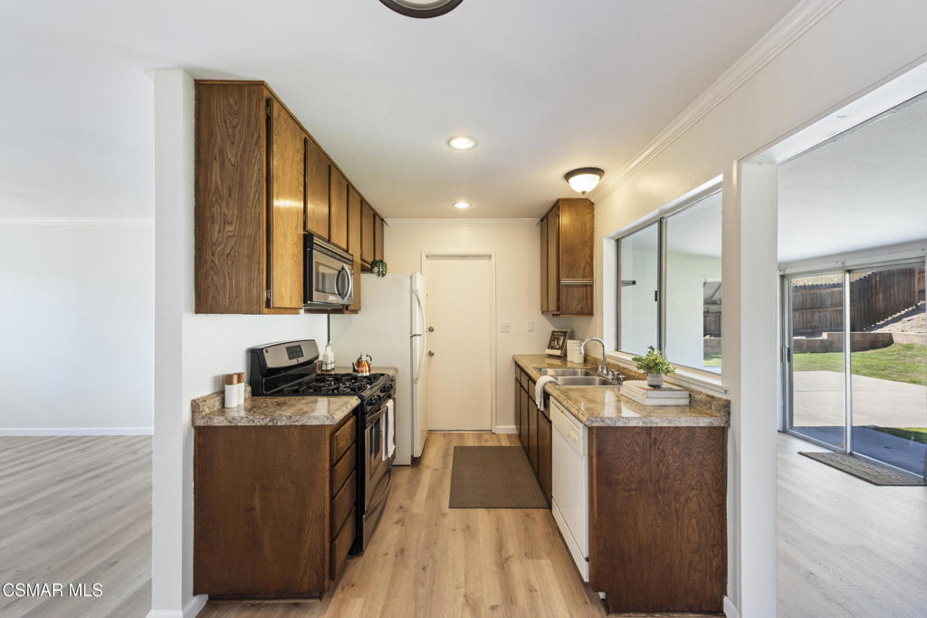 14773 Stanford Street Moorpark, CA 93021 - Photo 11 of 26 a kitchen with stainless steel appliances a stove top oven a sink a refrigerator and wooden floor
