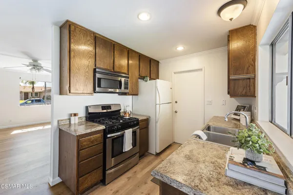 a kitchen with stainless steel appliances granite countertop a refrigerator stove microwave and sink
