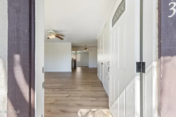 a view of a hallway with wooden floor and staircase