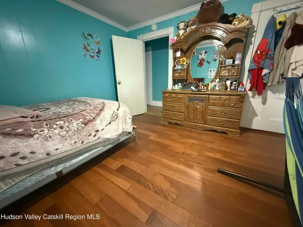 a bedroom with a bed and a mirror on the dresser