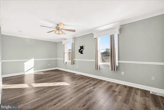 a view of a livingroom with wooden floor and a ceiling fan