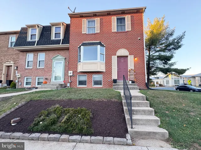 a front view of a house with a yard and trees