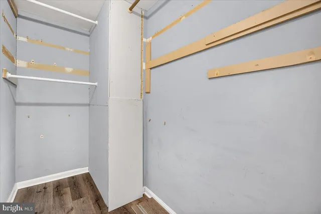 an empty room with wooden floor and ceiling fan