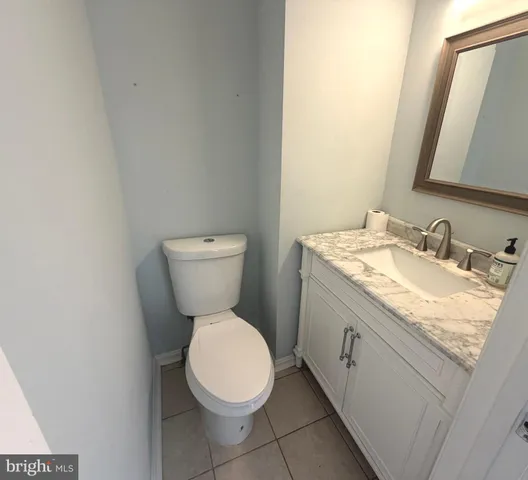 a bathroom with a granite countertop toilet and a sink