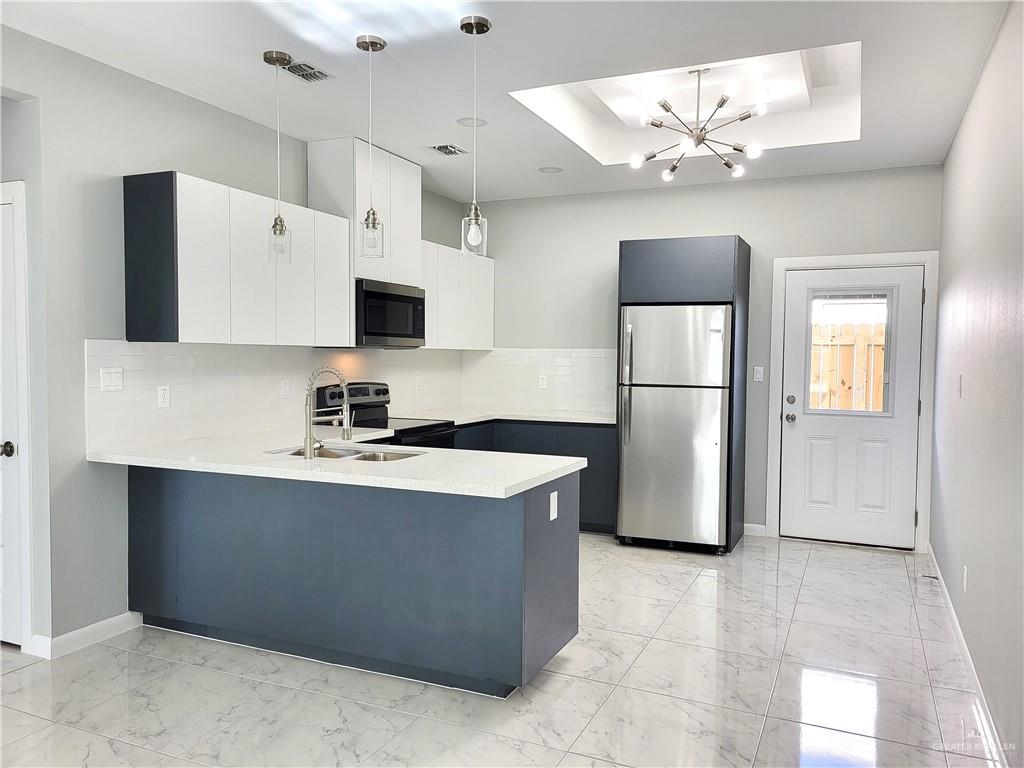 1416 East Hibiscus Avenue, Unit 3 McAllen, TX 78501 - Photo 4 of 11 a kitchen with stainless steel appliances granite countertop a sink stove and refrigerator
