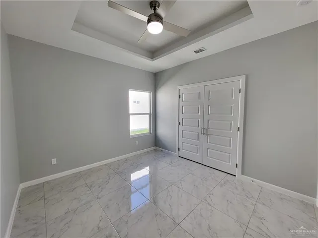 an empty room with fan and windows