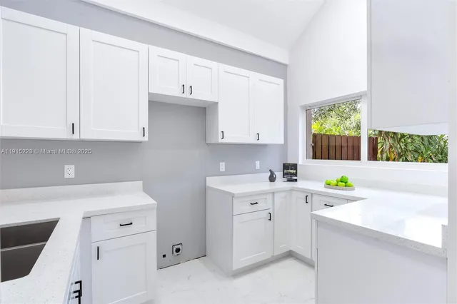 a kitchen with a sink cabinets and window