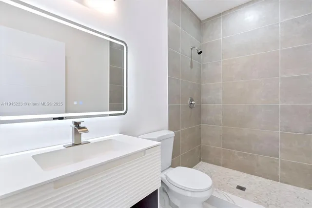 a bathroom with a sink a toilet a mirror and shower