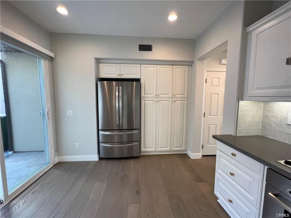 53 Bellwind Irvine, CA 92603 - Photo 3 of 12 an empty room with wooden floor cabinet and windows