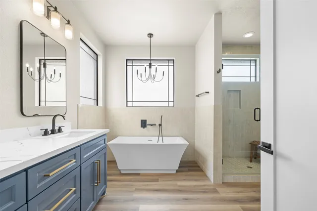 a bathroom with a double vanity sink mirror and windows