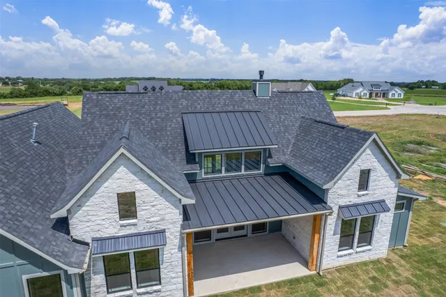 an aerial view of house with yard and ocean view