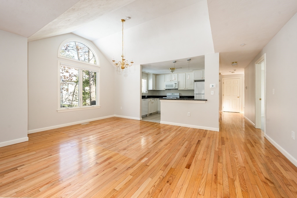13 Pga Lane, Unit 424 Mashpee, MA 02649 - Photo 4 of 19 a view of a kitchen with microwave and wooden floor