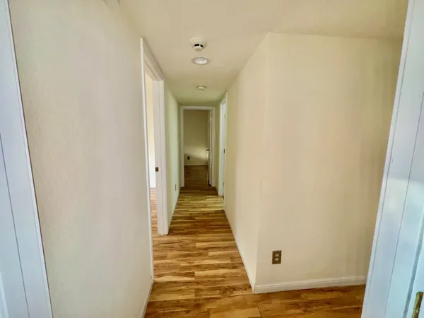 a view of a hallway with wooden floor