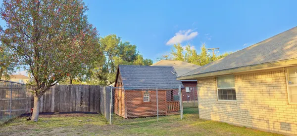 a view of a backyard with wooden fence