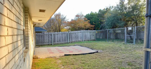 a view of a backyard with wooden fence