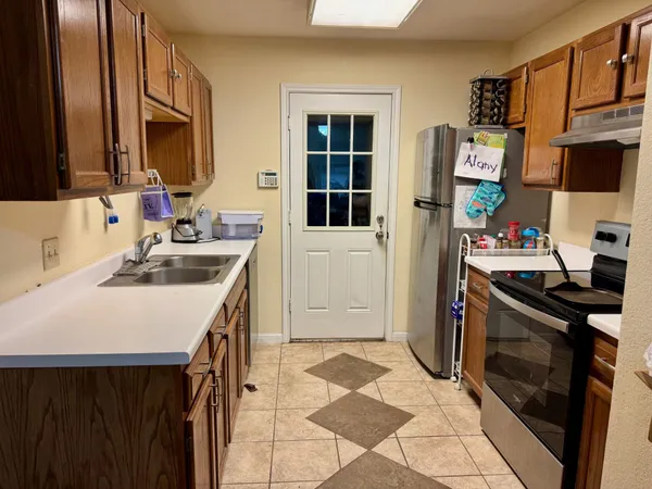 a kitchen with a sink stove and refrigerator