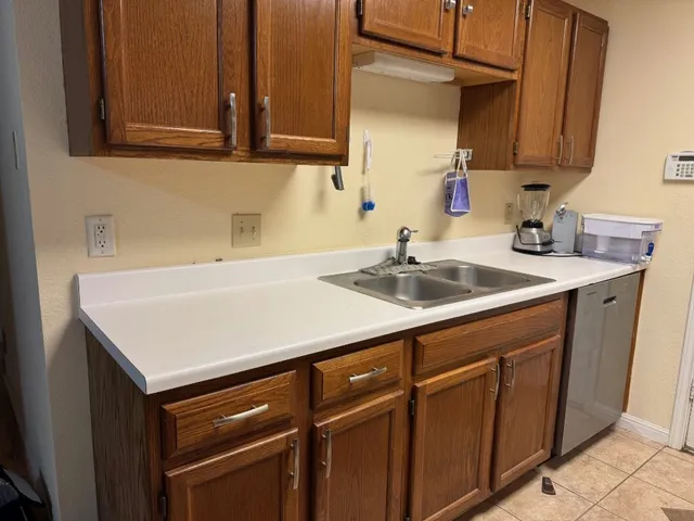 a kitchen with a sink cabinets and a window