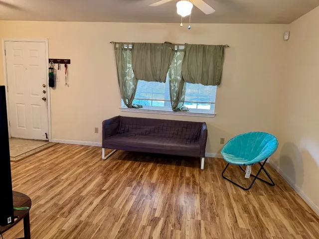 a living room with a bed furniture and a wooden floor