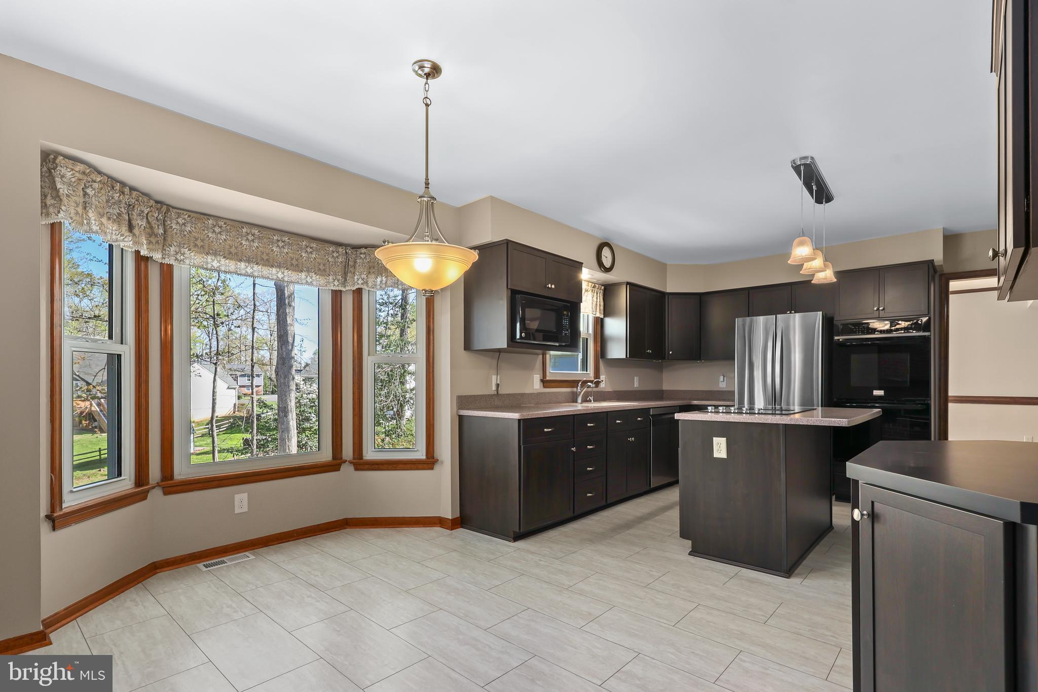233 Choptank Road Stafford, VA 22556 - Photo 15 of 65 a kitchen with stainless steel appliances granite countertop a refrigerator a sink dishwasher a stove and a dining table with wooden floor