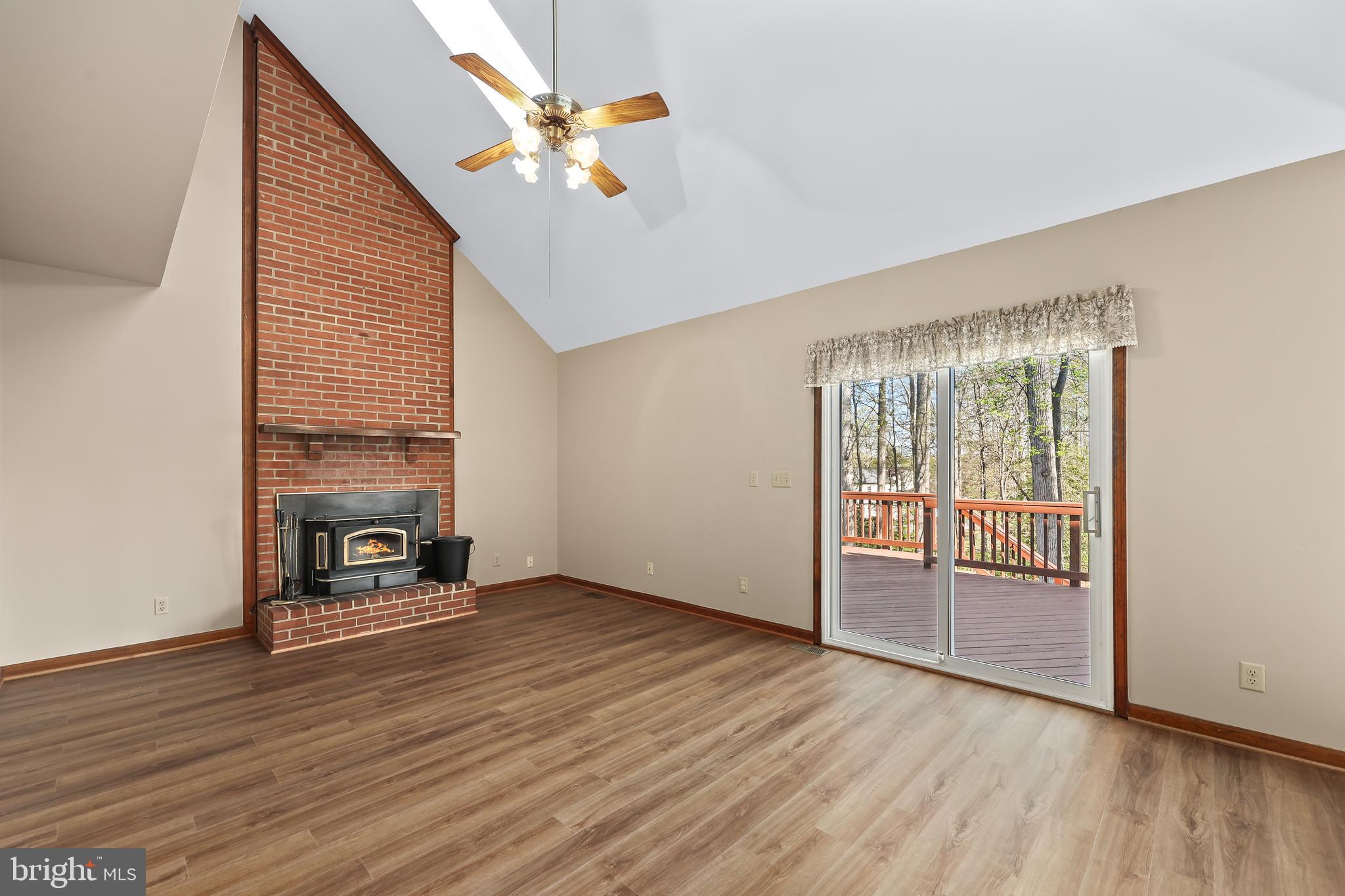 233 Choptank Road Stafford, VA 22556 - Photo 18 of 65 an empty room with wooden floor fireplace and windows