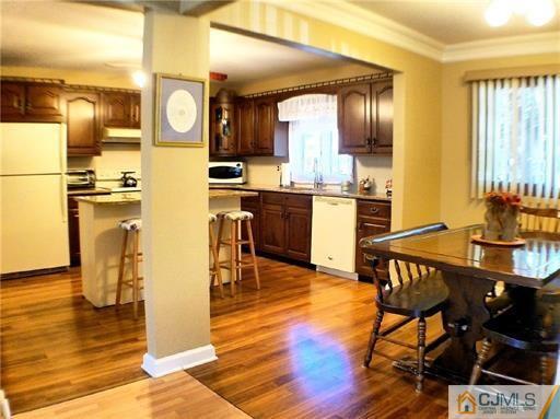 21 Ridge Road Old Bridge, NJ 08857 - Photo 8 of 23 a open kitchen with stainless steel appliances granite countertop a refrigerator a stove top oven and a dining table with wooden floor