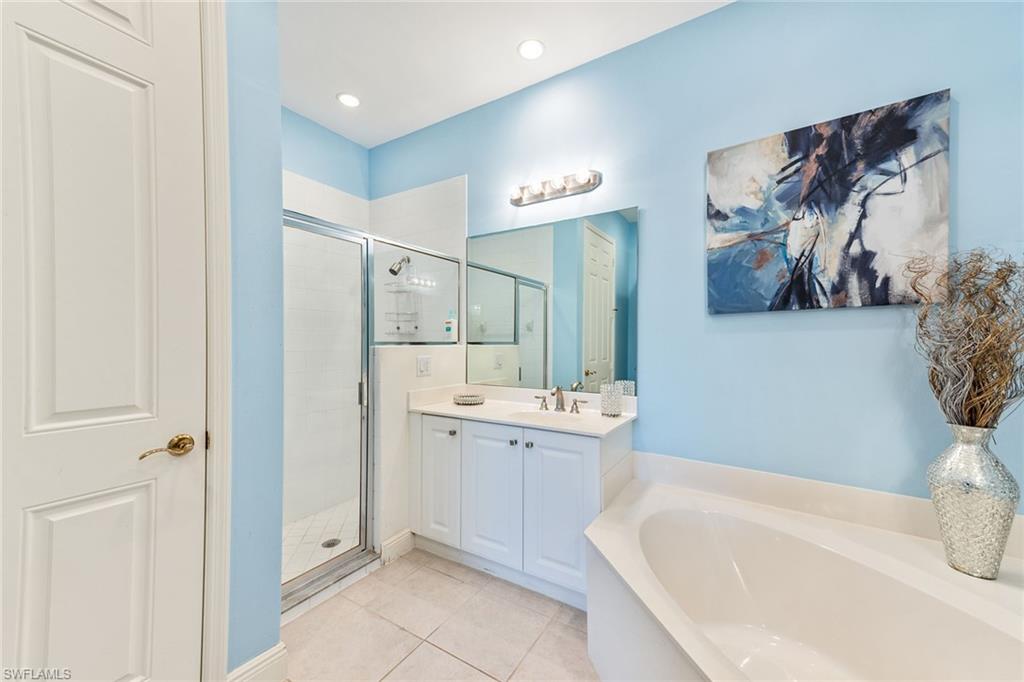9275 Museo Circle, Unit 103 Naples, FL 34114 - Photo 16 of 49 a bathroom with a bathtub sink and mirror