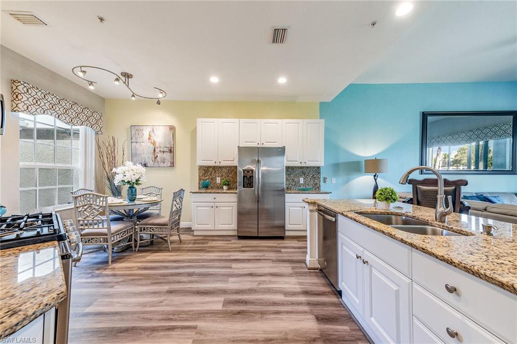 9275 Museo Circle, Unit 103 Naples, FL 34114 - Photo 9 of 49 a large kitchen with stainless steel appliances kitchen island granite countertop a large counter top stainless steel appliances and cabinets