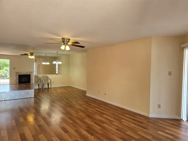a view of an empty room with a fireplace and a window