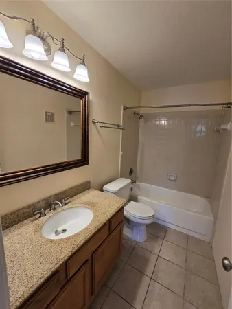 a bathroom with a granite countertop sink toilet a mirror and shower