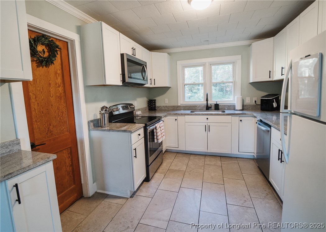 9778 Highway 24 Carthage, NC 28327 - Photo 15 of 47 a kitchen with a sink a stove top oven a refrigerator and cabinets