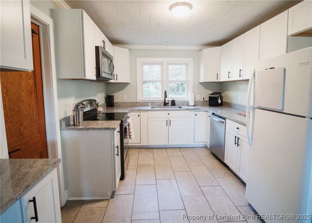 9778 Highway 24 Carthage, NC 28327 - Photo 16 of 47 a kitchen with white cabinets and white appliances