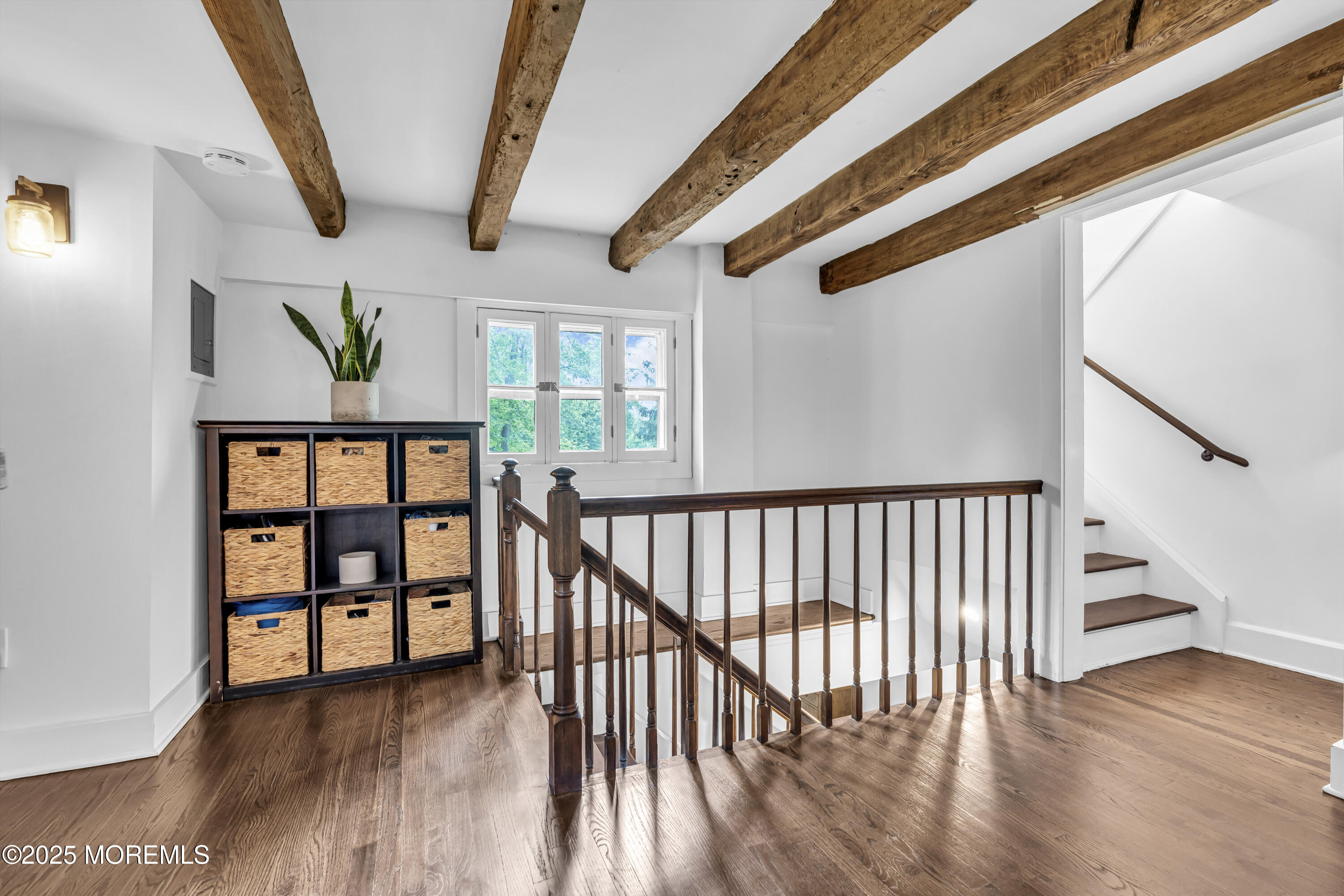 2041 Raritan Road Scotch Plains, NJ 07076 - Photo 51 of 106 a view of staircase with lots of frames on wall and wooden floor