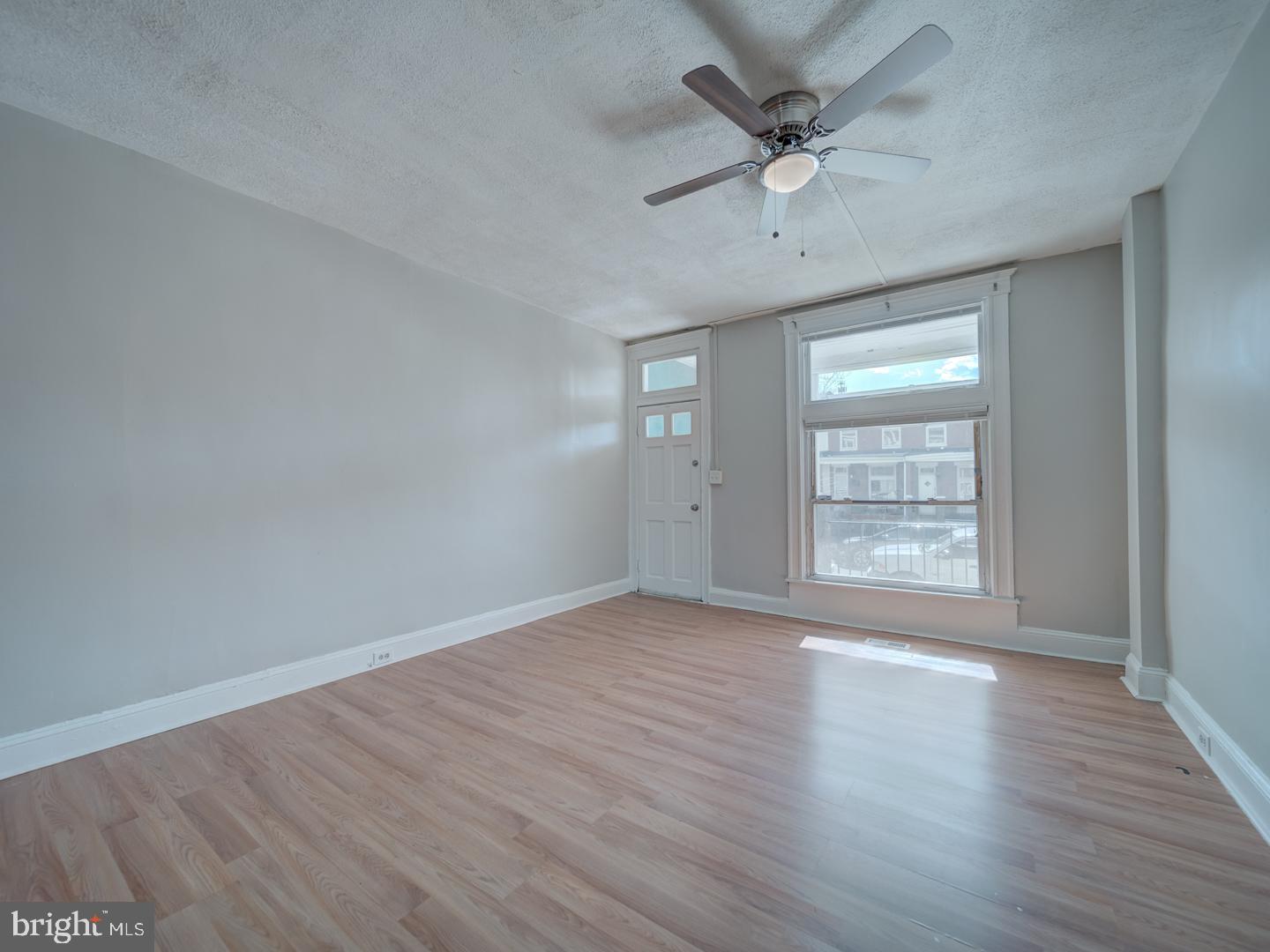 1716 Homestead Street Baltimore, MD 21218 - Photo 12 of 48 an empty room with wooden floor chandelier fan and windows
