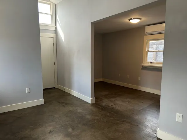 an empty room with windows and closet