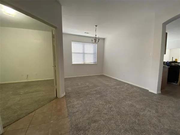 an empty room with windows and refrigerator