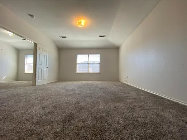 an empty room with windows and closet