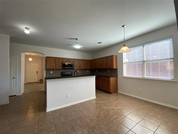 a kitchen with stainless steel appliances kitchen island granite countertop a refrigerator and a stove top oven