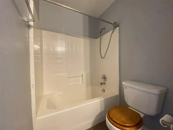 a white toilet and tub sitting next to a bathroom sink