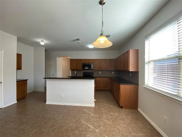 a kitchen with stainless steel appliances granite countertop a sink a stove a refrigerator a microwave oven with white cabinets