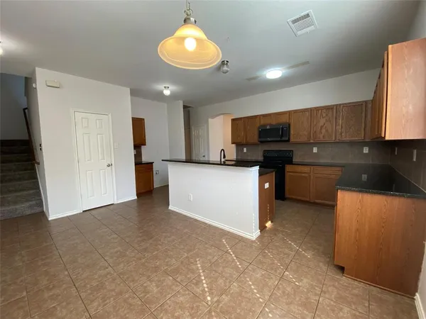 a kitchen with stainless steel appliances granite countertop a refrigerator stove microwave and sink