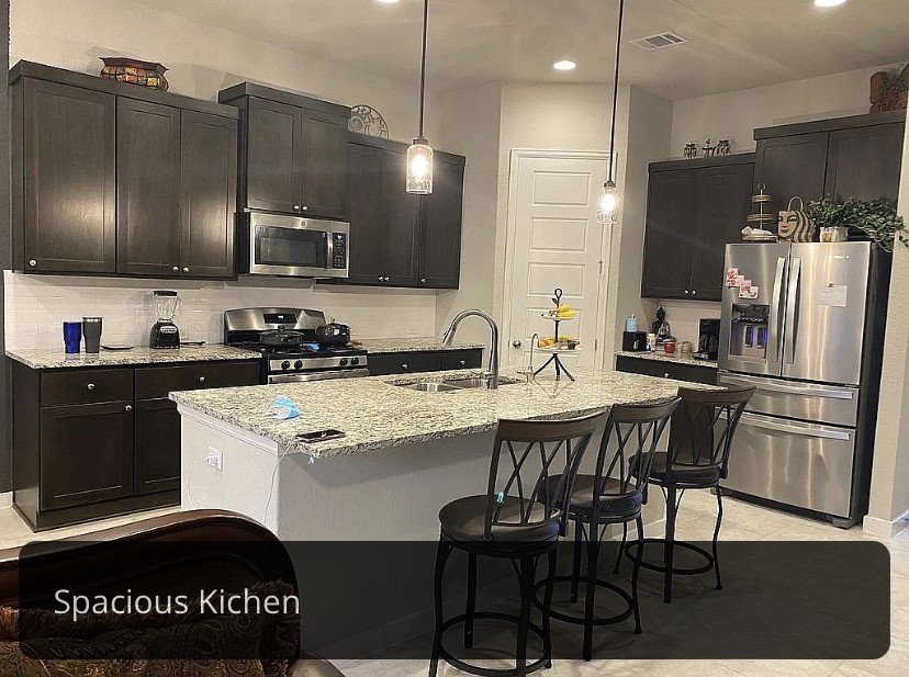 2017 Palmera Ridge Boulevard Leander, TX 78641 - Photo 5 of 6 Granite counters and dark cabinetry define this inviting kitchen.