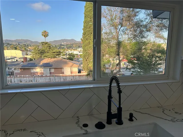 an empty room with wooden floor closet and windows