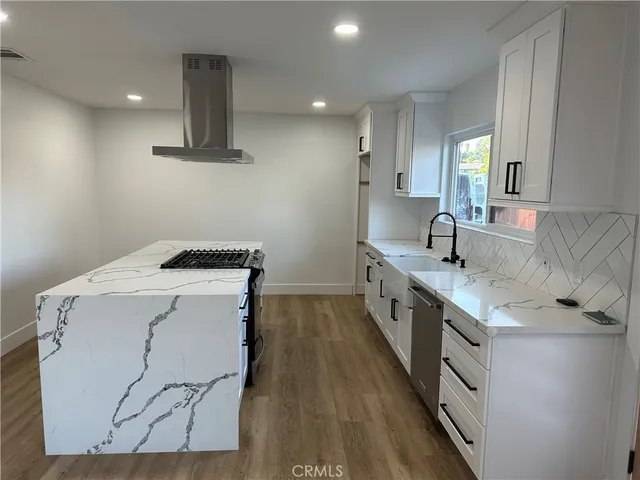 a kitchen with a sink a stove and chairs