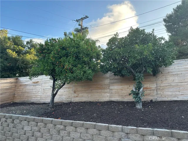 an empty room with wooden floor mirror and windows