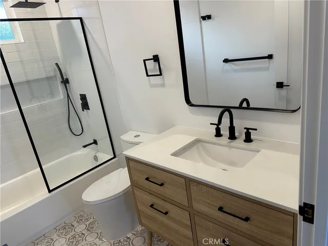 a bathroom with a sink a toilet and mirror